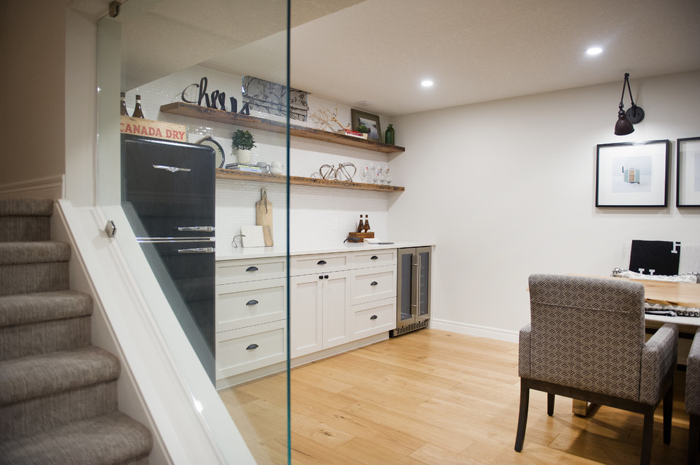 Basement - mid-sized transitional underground light wood floor and beige floor basement idea with gray walls, a standard fireplace and a stone fireplace