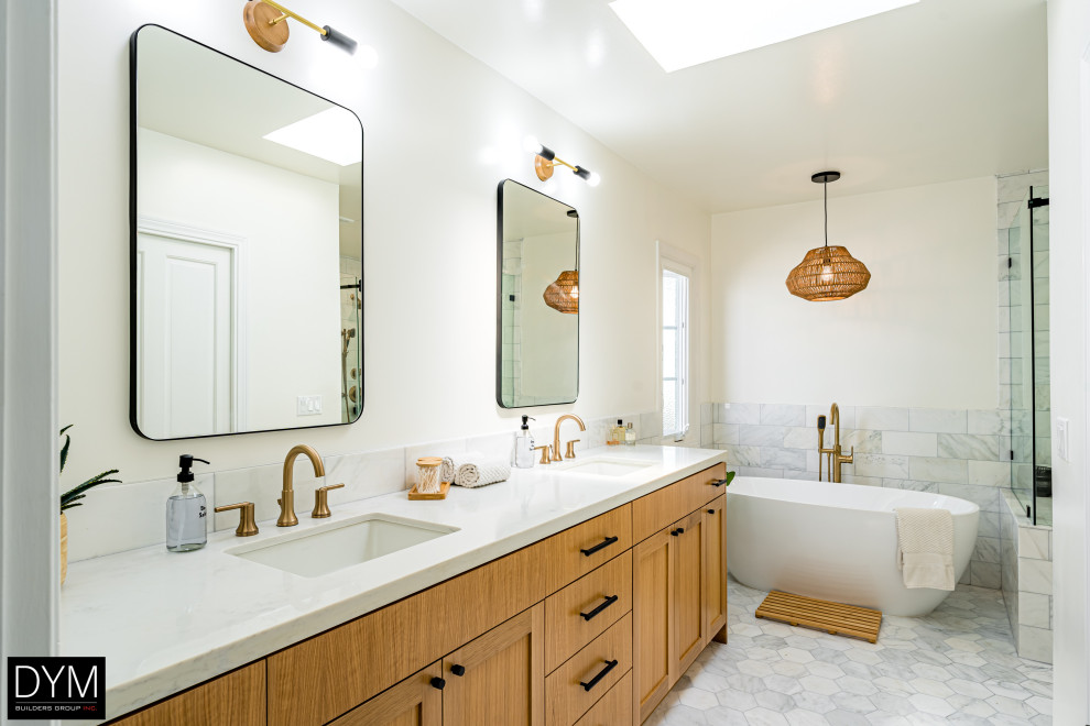 This is an example of a large midcentury master bathroom in Los Angeles with shaker cabinets, medium wood cabinets, a freestanding tub, white tile, cement tile, marble benchtops, white benchtops, a double vanity, a built-in vanity, a corner shower, a sliding shower screen, a one-piece toilet, white walls, porcelain floors, a drop-in sink, grey floor, a shower seat, wallpaper and wallpaper.