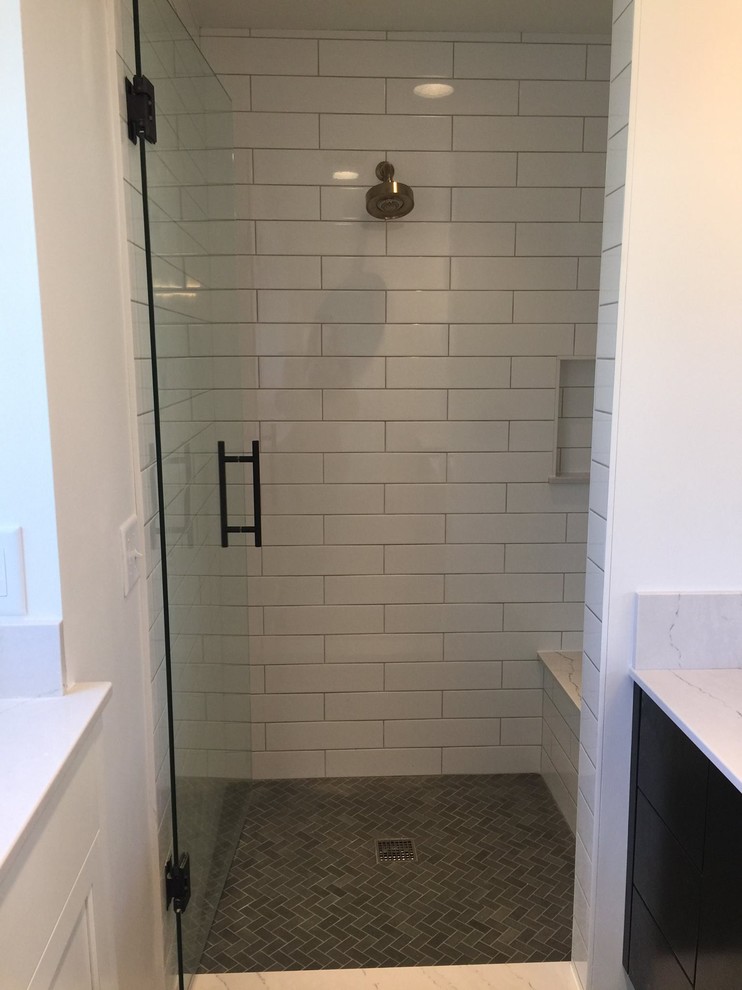 Photo of a mid-sized modern master bathroom in Minneapolis with dark wood cabinets, an alcove shower, white tile, subway tile, white walls, mosaic tile floors, flat-panel cabinets, an undermount sink and marble benchtops.