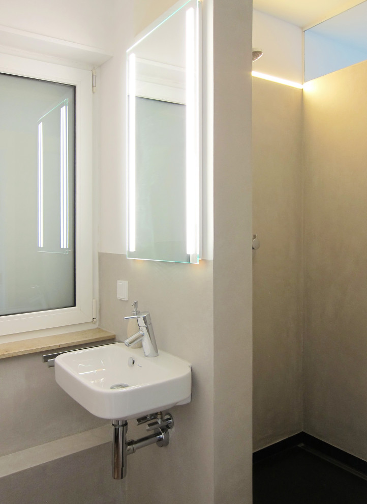 Kleines Modernes Duschbad mit Duschnische, Wandtoilette, beigen Fliesen, weißer Wandfarbe, Vinylboden, Wandwaschbecken, braunem Boden, Falttür-Duschabtrennung und Einzelwaschbecken in Köln
