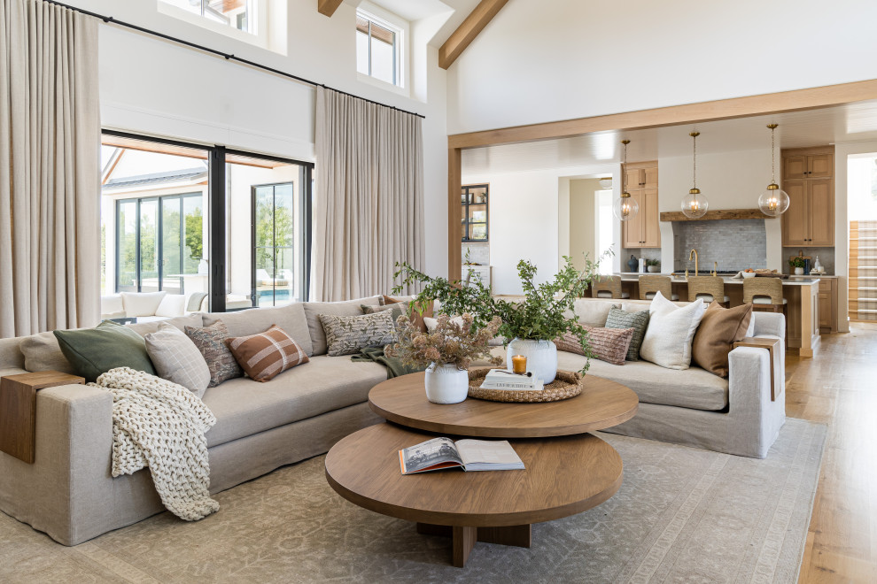 Example of a transitional light wood floor, beige floor, exposed beam and vaulted ceiling living room design in Orange County with white walls
