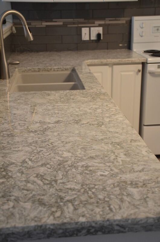 Example of a mid-sized transitional u-shaped vinyl floor open concept kitchen design in Toronto with an undermount sink, raised-panel cabinets, white cabinets, quartzite countertops, gray backsplash, glass tile backsplash, white appliances and a peninsula