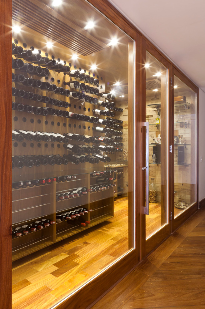 Inspiration for a large contemporary wine cellar in Other with medium hardwood floors and storage racks.