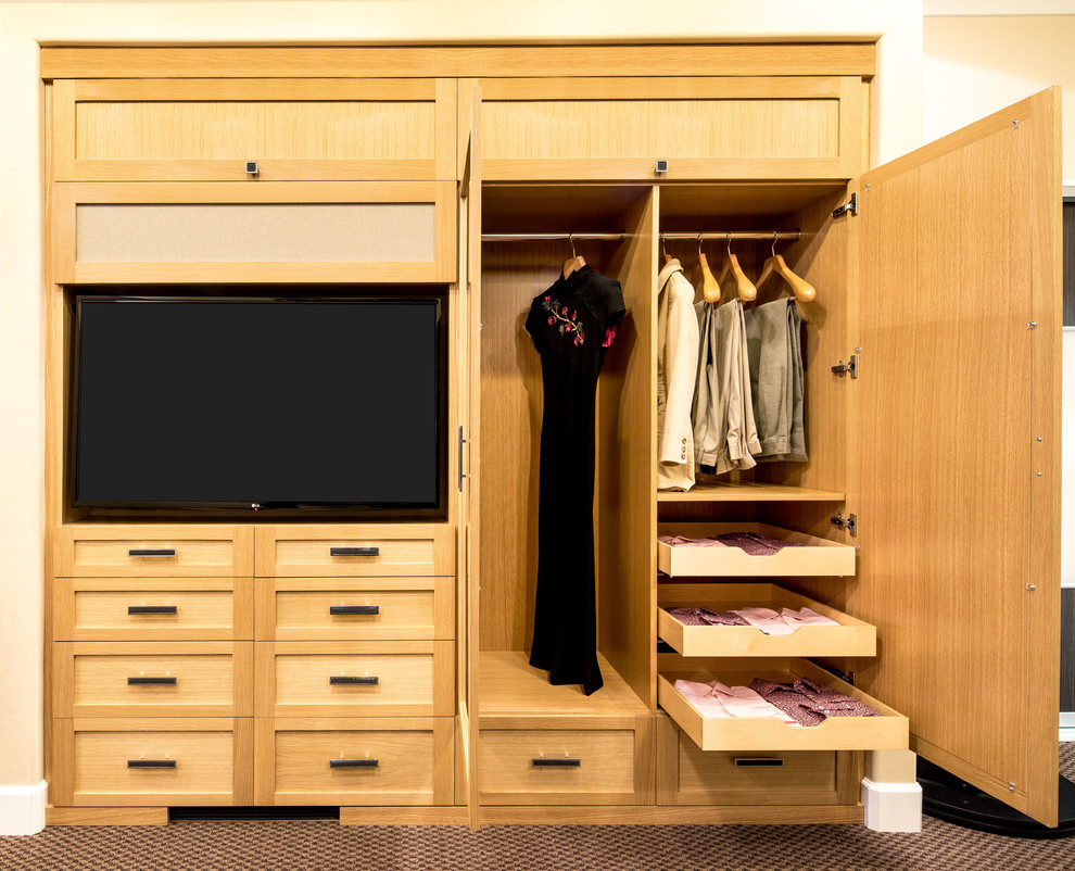 This is an example of a small transitional gender-neutral built-in wardrobe in San Francisco with shaker cabinets, light wood cabinets and carpet.