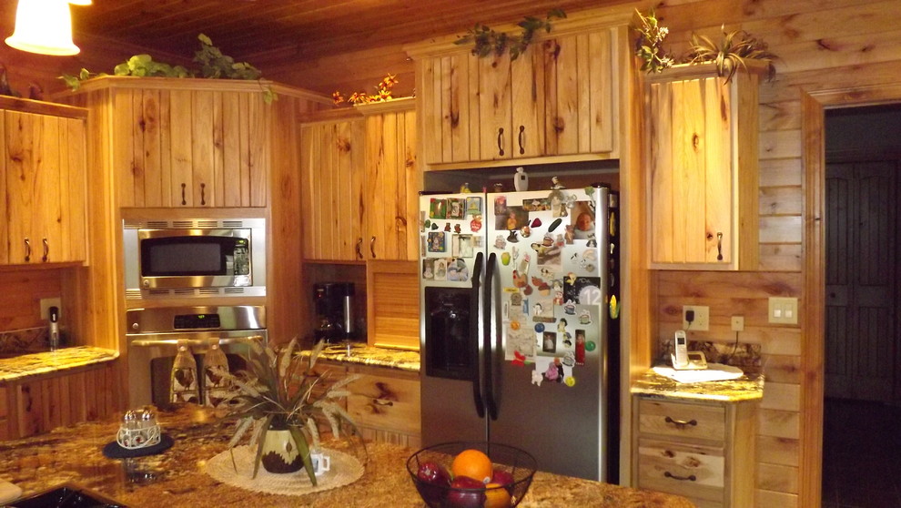 Example of a mountain style u-shaped porcelain tile and brown floor enclosed kitchen design with an undermount sink, stainless steel appliances and an island