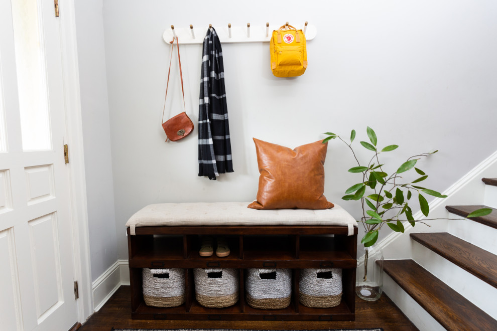 Example of a small transitional dark wood floor and brown floor entryway design in DC Metro with white walls and a white front door