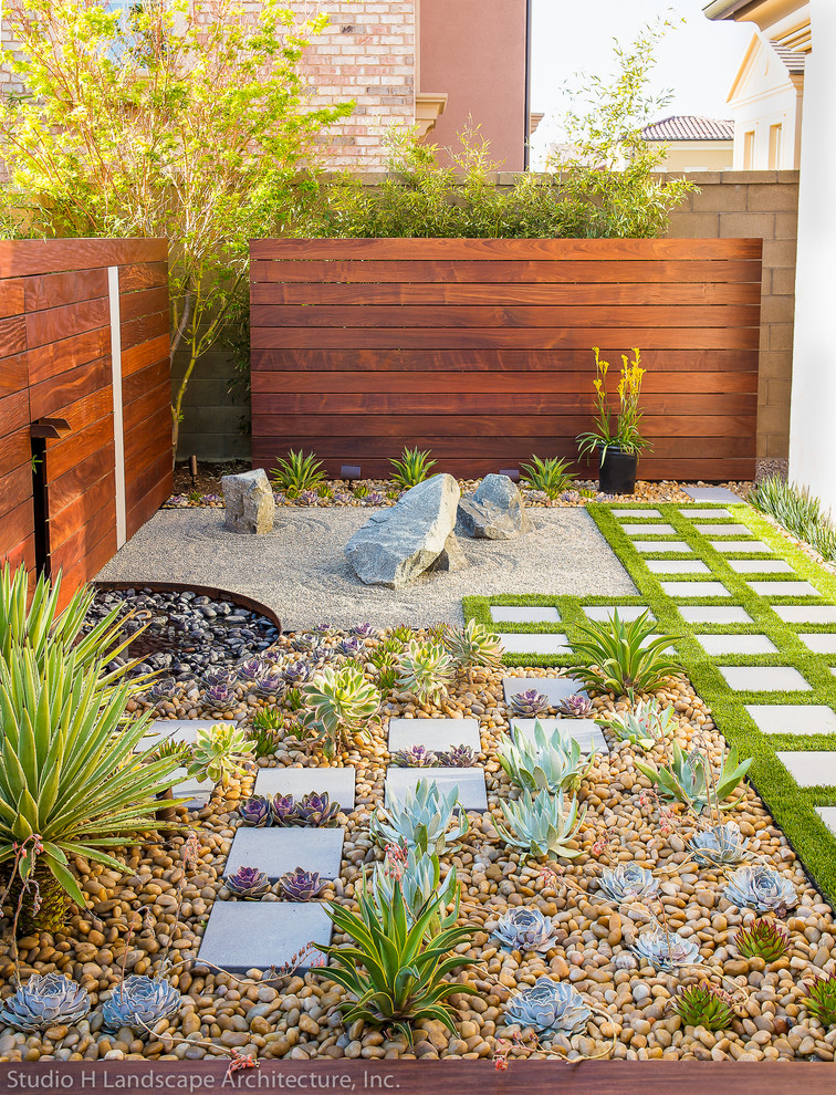 Design ideas for a small contemporary side yard partial sun xeriscape in Orange County with natural stone pavers and a garden path.