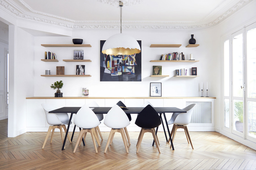 Design ideas for a mid-sized scandinavian separate dining room in Paris with white walls, light hardwood floors and no fireplace.