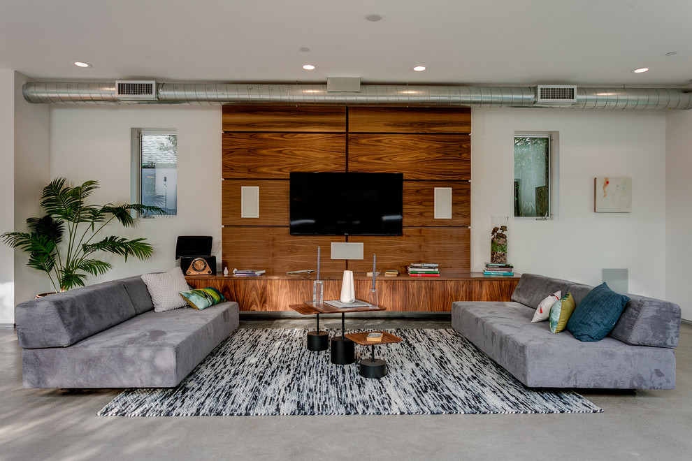 Design ideas for a mid-sized contemporary formal open concept living room in Los Angeles with white walls, concrete floors and a wall-mounted tv.