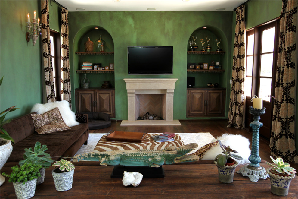 This is an example of a large traditional formal enclosed living room in Los Angeles with green walls, dark hardwood floors, a wall-mounted tv, a standard fireplace, a stone fireplace surround and brown floor.