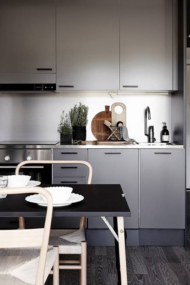 Eat-in kitchen - contemporary single-wall dark wood floor eat-in kitchen idea with a drop-in sink, flat-panel cabinets, gray cabinets, stainless steel countertops, stainless steel appliances and no island