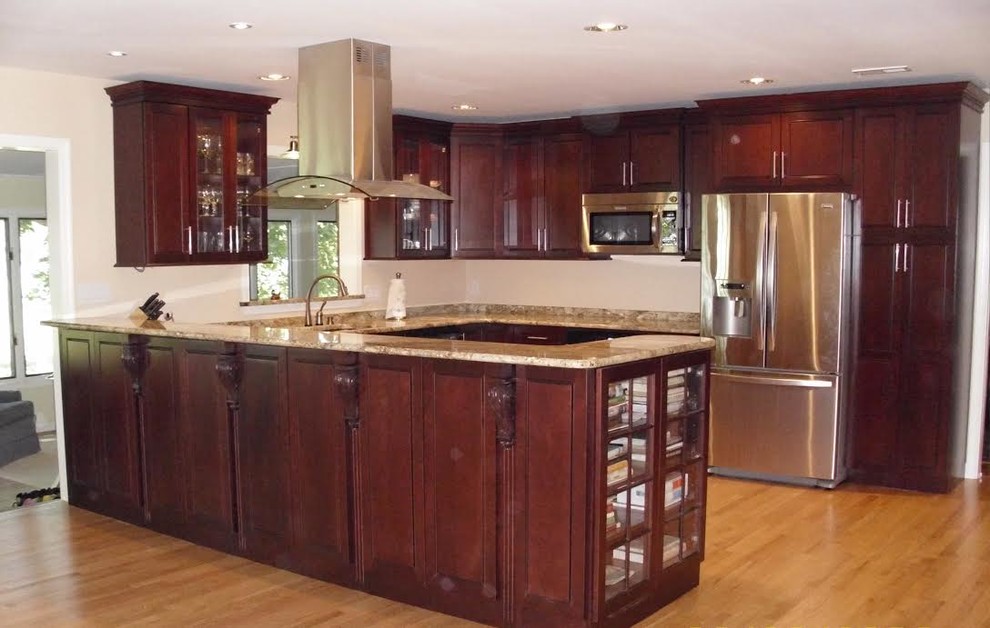 Mid-sized transitional u-shaped light wood floor and beige floor enclosed kitchen photo in Baltimore with an undermount sink, shaker cabinets, dark wood cabinets, granite countertops, stainless steel appliances and a peninsula