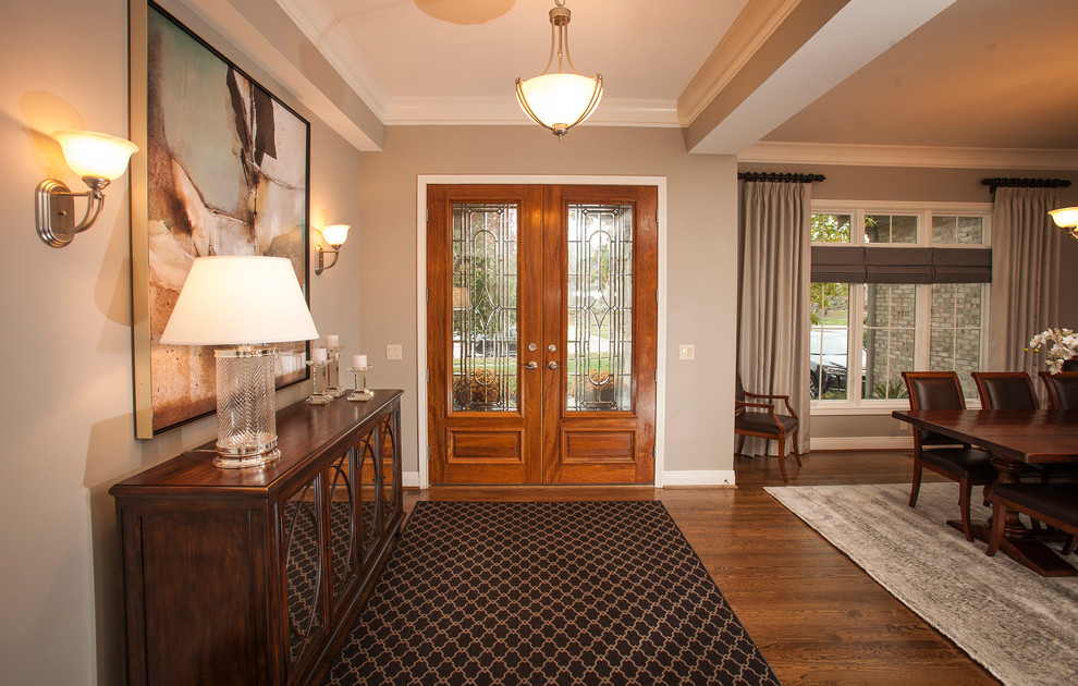 This is an example of a large transitional foyer in Cincinnati with grey walls and dark hardwood floors.