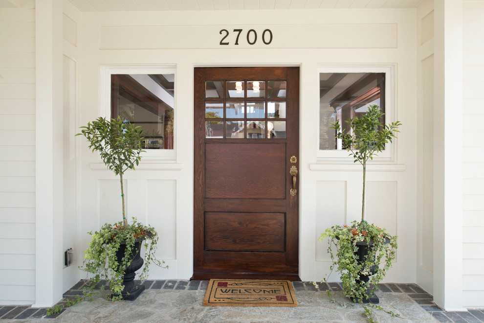 Photo of a large arts and crafts front door in Los Angeles with a single front door, a dark wood front door, white walls and dark hardwood floors.