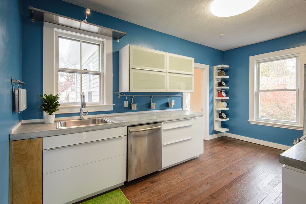 Mid-sized contemporary galley separate kitchen in Boston with a drop-in sink, flat-panel cabinets, white cabinets, concrete benchtops, blue splashback, stainless steel appliances, dark hardwood floors, no island and brown floor.