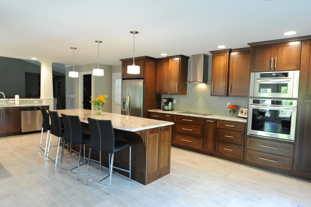 Huge transitional ceramic tile open concept kitchen photo in Chicago with an undermount sink, shaker cabinets, medium tone wood cabinets, granite countertops, gray backsplash, glass tile backsplash, stainless steel appliances and an island