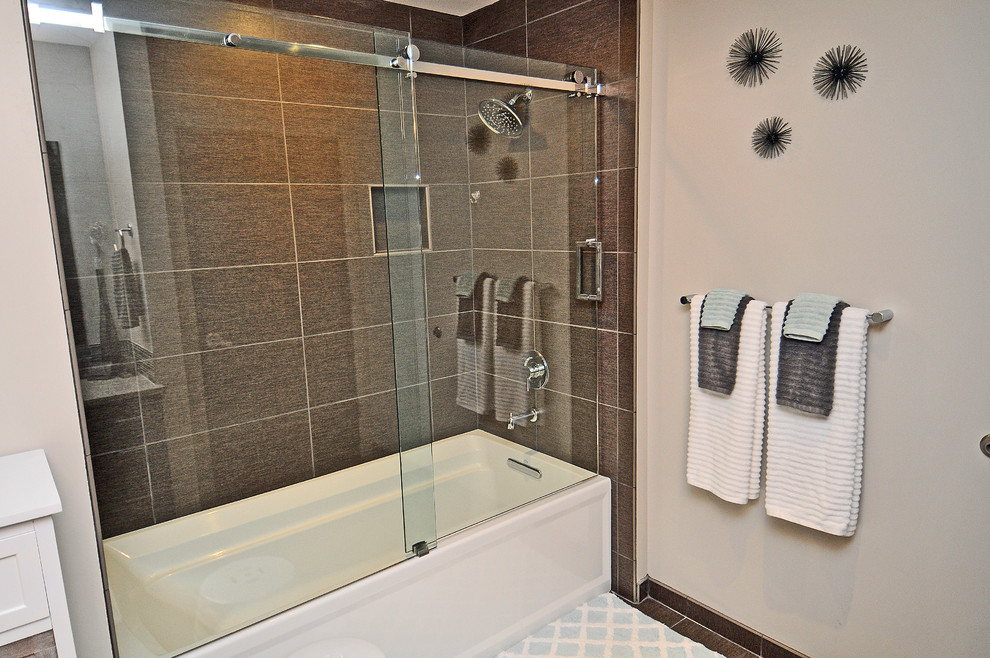 Design ideas for a mid-sized transitional 3/4 bathroom in Omaha with shaker cabinets, dark wood cabinets, an alcove tub, a shower/bathtub combo, a two-piece toilet, brown tile, porcelain tile, beige walls, an undermount sink, granite benchtops and porcelain floors.