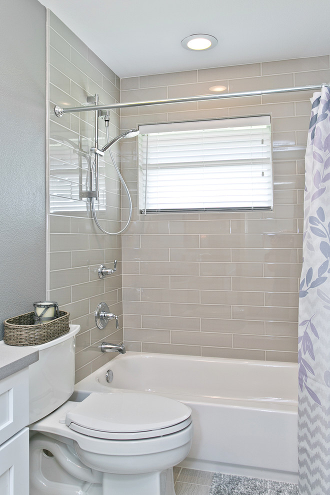 Design ideas for a mid-sized transitional 3/4 bathroom in Dallas with an undermount sink, raised-panel cabinets, white cabinets, solid surface benchtops, an alcove tub, a curbless shower, a two-piece toilet, gray tile, subway tile, grey walls and porcelain floors.