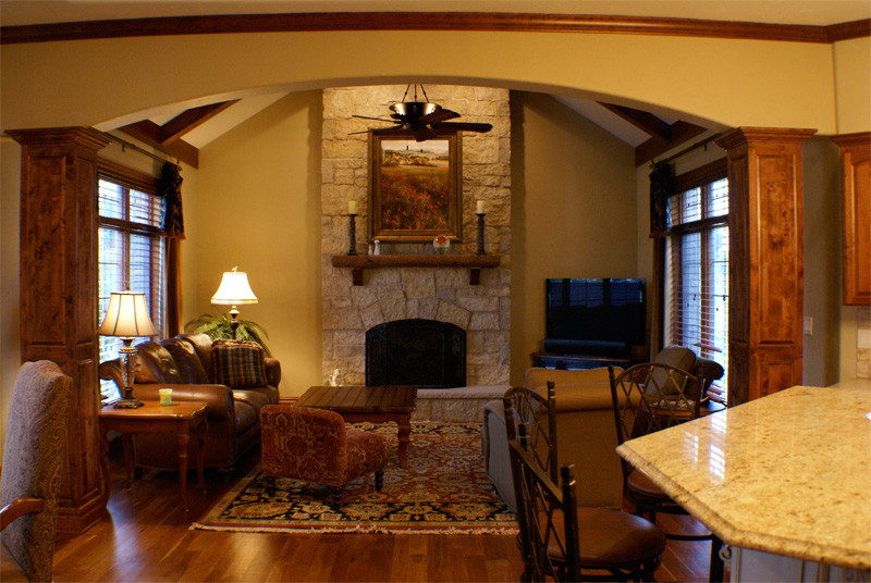 Inspiration for a mid-sized transitional formal enclosed living room in Milwaukee with beige walls, medium hardwood floors, a standard fireplace, a stone fireplace surround and a freestanding tv.