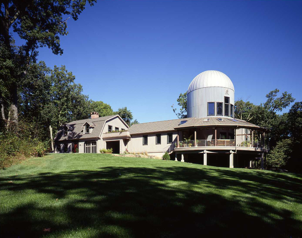 Inspiration for a large country two-storey beige exterior in Manchester with wood siding and a gambrel roof.