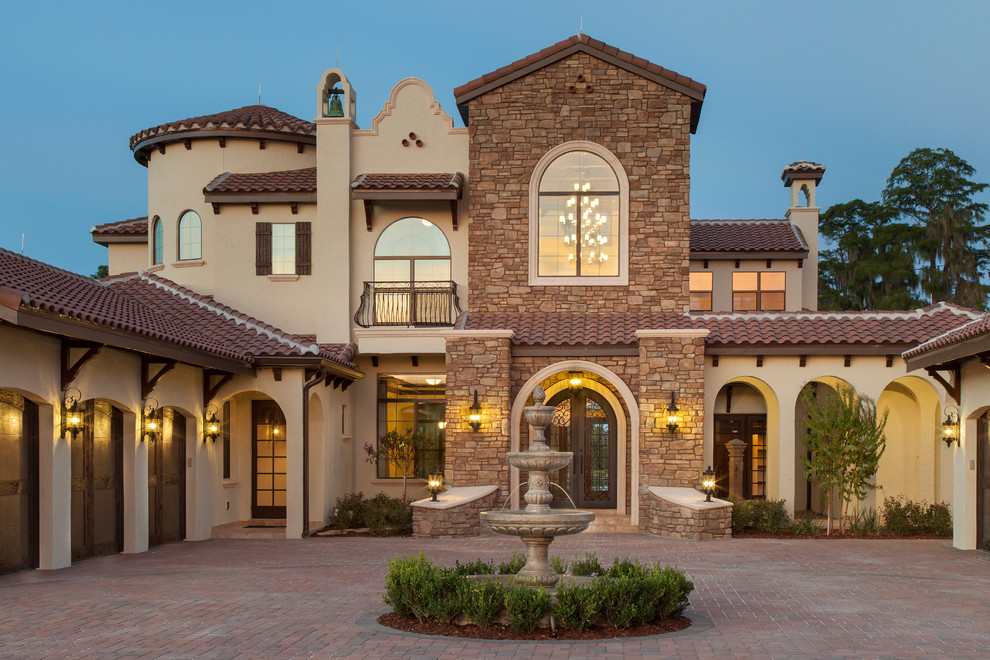 Design ideas for an expansive mediterranean two-storey stucco beige exterior in Orlando with a hip roof.