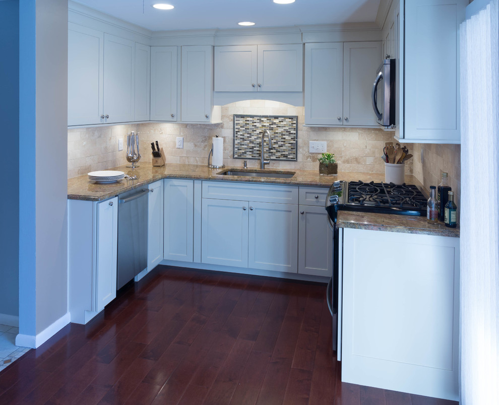 Inspiration for a small traditional u-shaped separate kitchen in Providence with no island, shaker cabinets, white cabinets, granite benchtops, beige splashback, stone tile splashback, stainless steel appliances, an undermount sink and medium hardwood floors.
