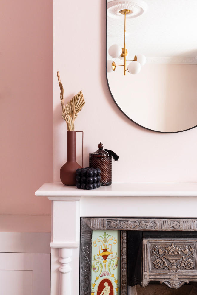 Modern inredning av ett mellanstort vardagsrum, med ett finrum, rosa väggar, ljust trägolv, en standard öppen spis, en spiselkrans i trä, TV i ett hörn och beiget golv