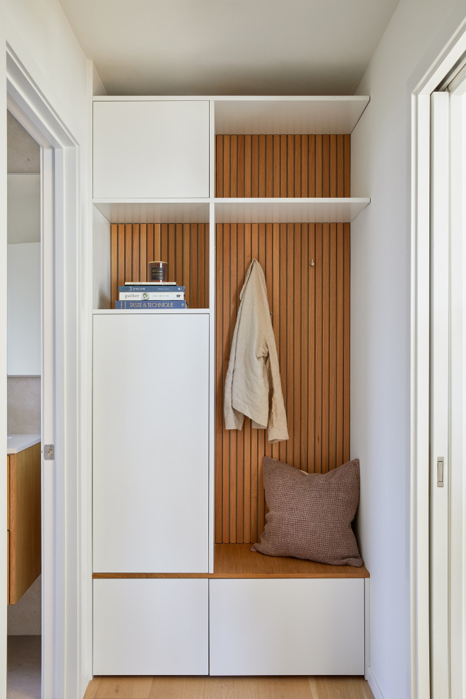 This is an example of a large modern guest bedroom in San Francisco with white walls, light hardwood flooring and brown floors.