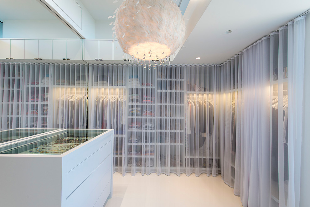 Contemporary women's storage and wardrobe in New York with white cabinets.