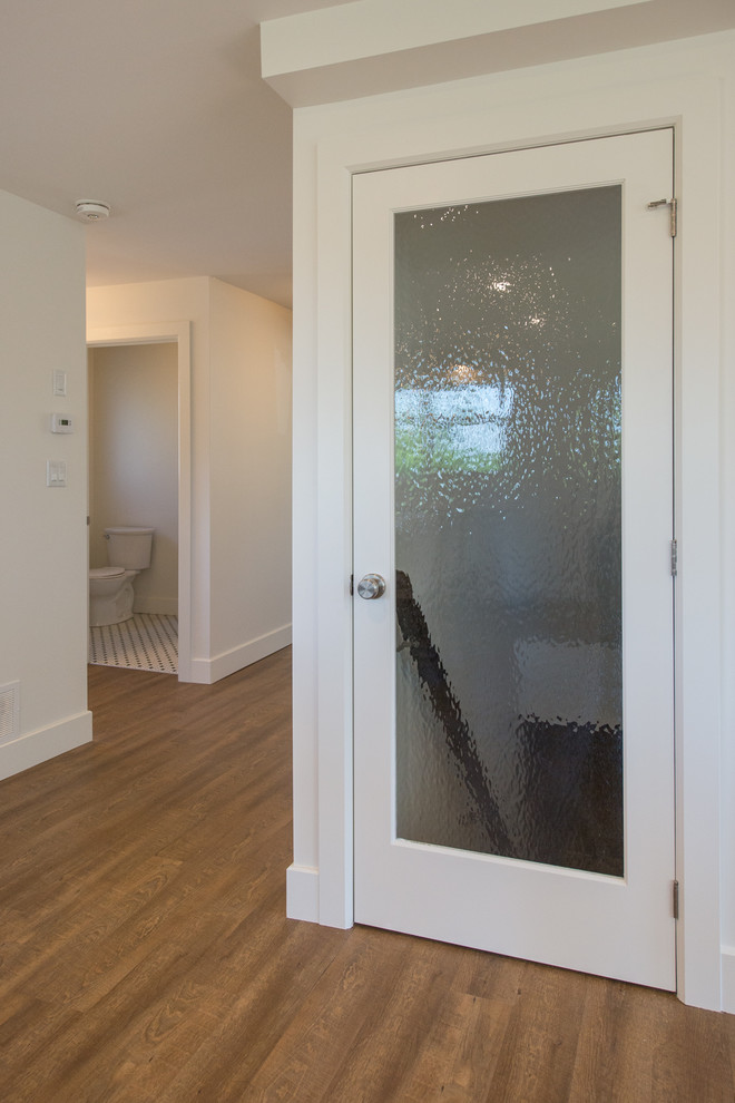 This is an example of a mid-sized contemporary hallway in Toronto with medium hardwood floors, brown floor and white walls.