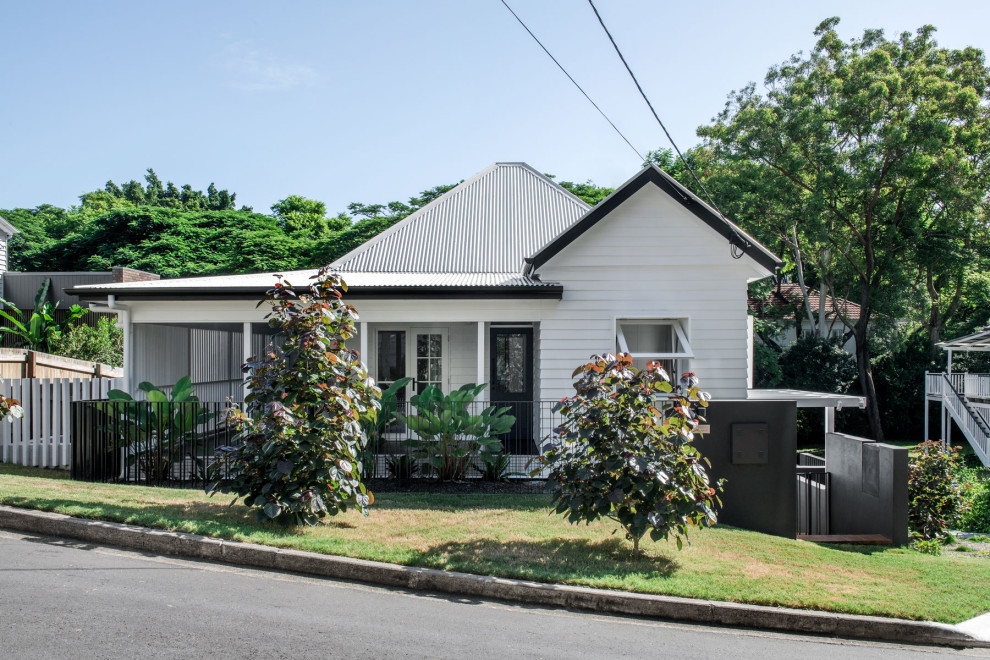 Inspiration for a mid-sized traditional two-storey white house exterior in Brisbane with concrete fiberboard siding, a gable roof and a metal roof.