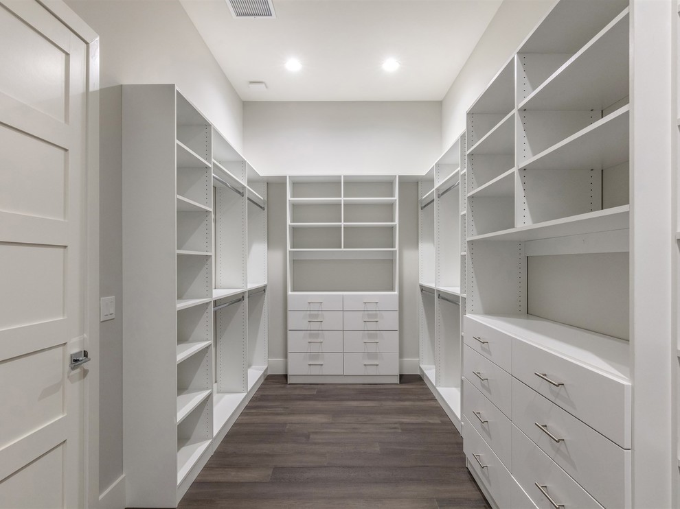 Large transitional gender-neutral walk-in wardrobe in Orlando with flat-panel cabinets, white cabinets, dark hardwood floors and brown floor.
