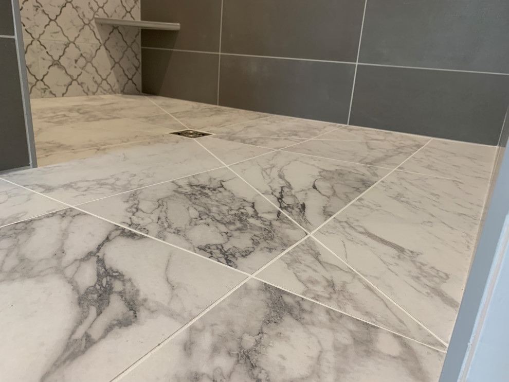 Exempel på ett mellanstort klassiskt vit vitt en-suite badrum, med släta luckor, grå skåp, en kantlös dusch, grå kakel, porslinskakel, grå väggar, klinkergolv i porslin, ett undermonterad handfat, bänkskiva i kvarts, grått golv och med dusch som är öppen