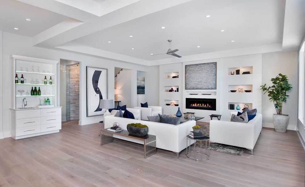 Design ideas for a contemporary open concept living room in Miami with white walls, light hardwood floors, a ribbon fireplace and beige floor.