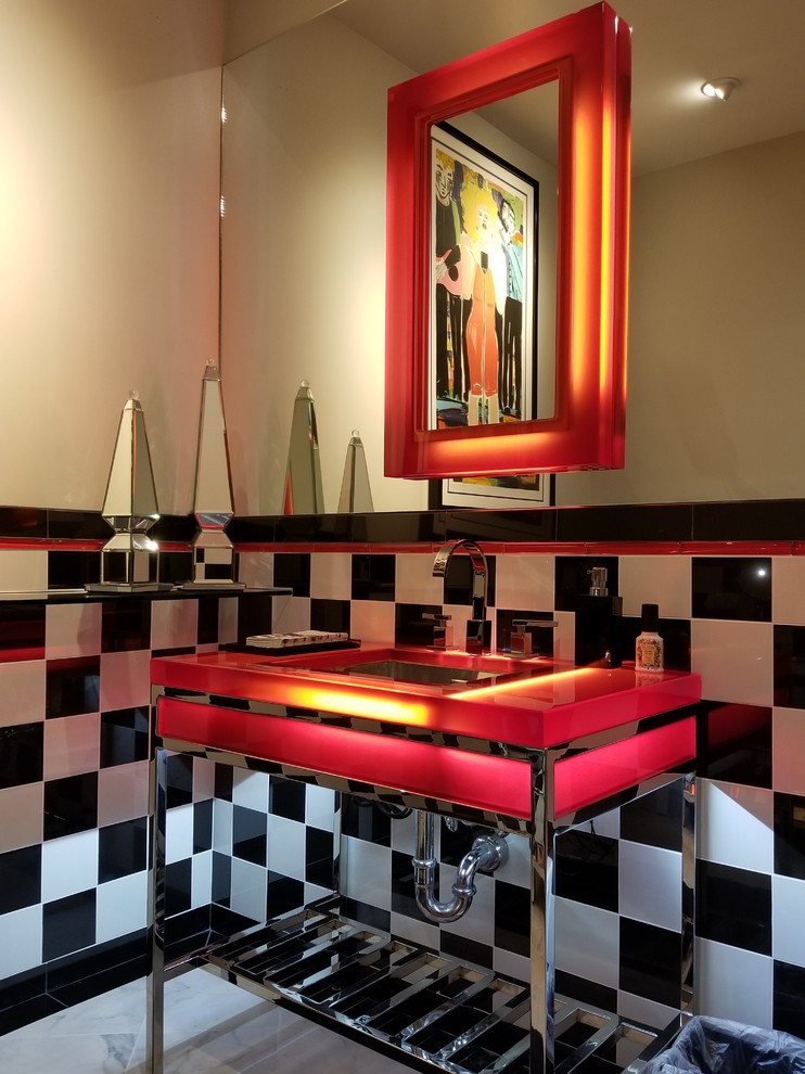 Photo of a mid-sized modern powder room in Hawaii with red benchtops, black and white tile, cement tile, beige walls, an undermount sink, glass benchtops and white floor.