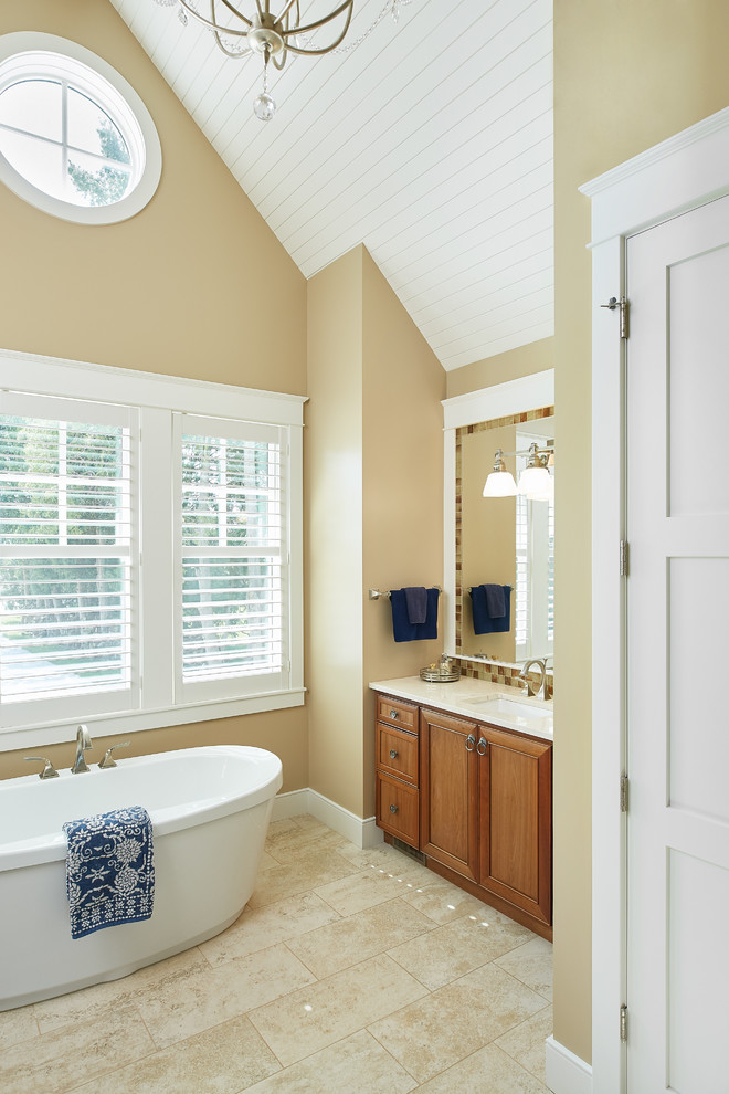 Design ideas for a traditional bathroom in Grand Rapids with brown cabinets, a freestanding tub, white walls, beige floor, white benchtops, a built-in vanity, vaulted and planked wall panelling.