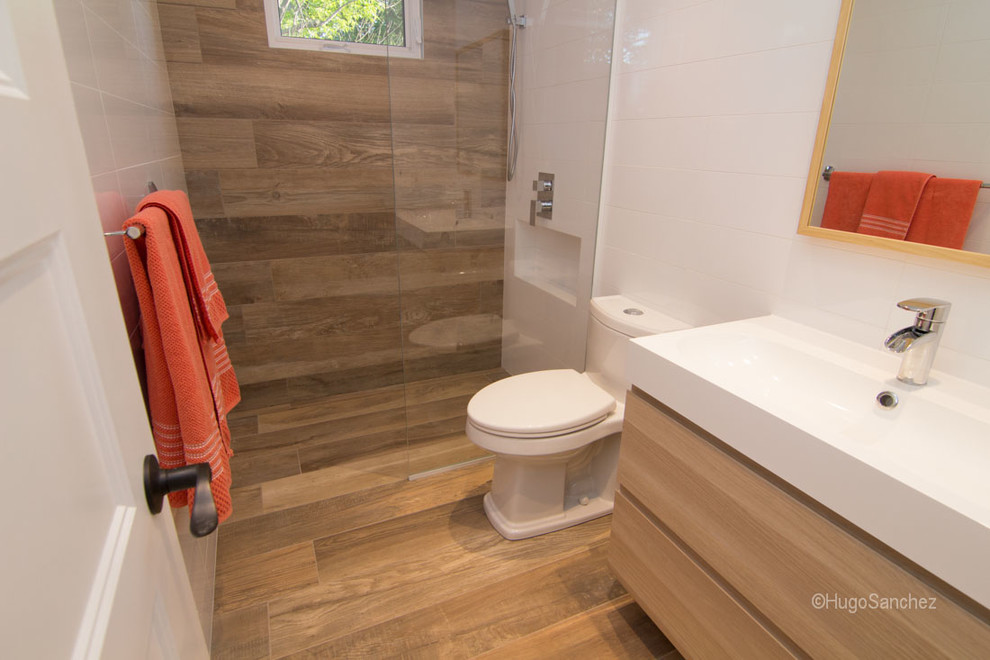 Photo of a small contemporary kids bathroom in Montreal with an integrated sink, flat-panel cabinets, light wood cabinets, a curbless shower, a one-piece toilet, white walls and porcelain floors.