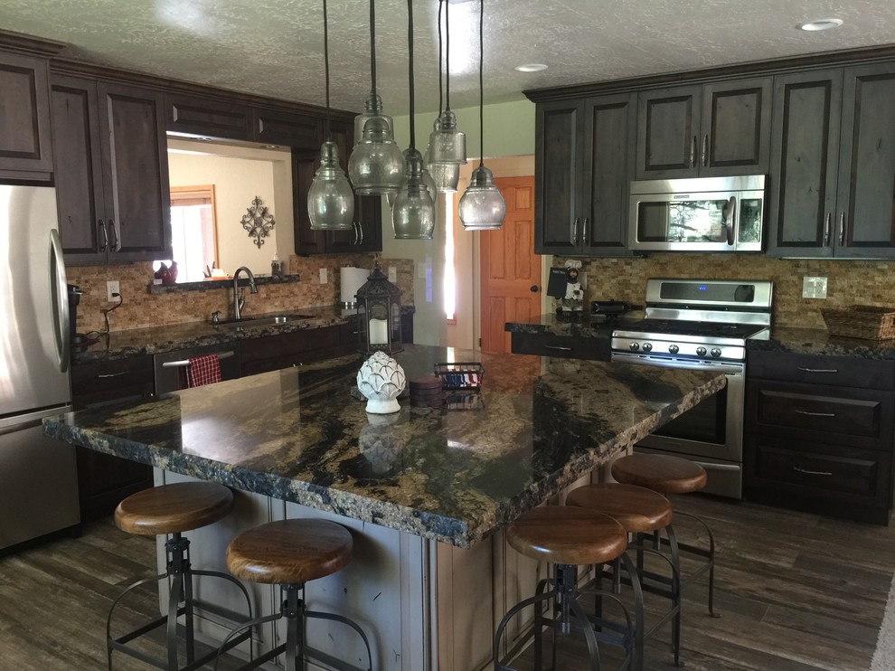 Inspiration for a large rustic l-shaped dark wood floor and brown floor enclosed kitchen remodel with an undermount sink, raised-panel cabinets, dark wood cabinets, quartz countertops, beige backsplash, stone tile backsplash, stainless steel appliances and an island