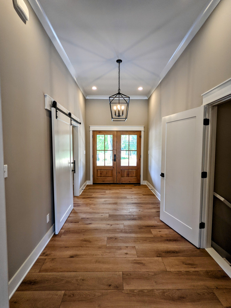 Großer Eingang mit Korridor, beiger Wandfarbe, braunem Holzboden, Doppeltür, brauner Haustür und braunem Boden in Indianapolis