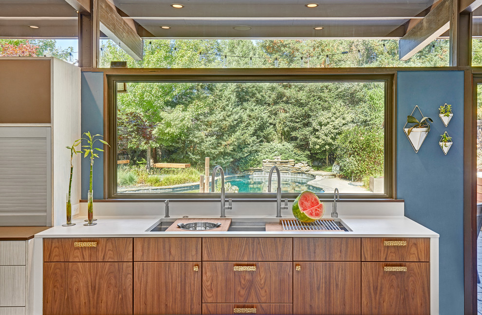 Design ideas for a mid-sized midcentury l-shaped open plan kitchen in Sacramento with an undermount sink, flat-panel cabinets, white cabinets, quartz benchtops, white splashback, stone slab splashback, white appliances, porcelain floors, with island and grey floor.