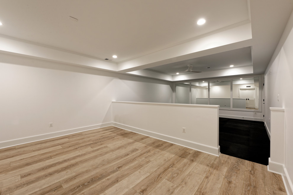 Multifunktionaler, Mittelgroßer Uriger Fitnessraum mit weißer Wandfarbe, braunem Holzboden, braunem Boden und gewölbter Decke in Sonstige