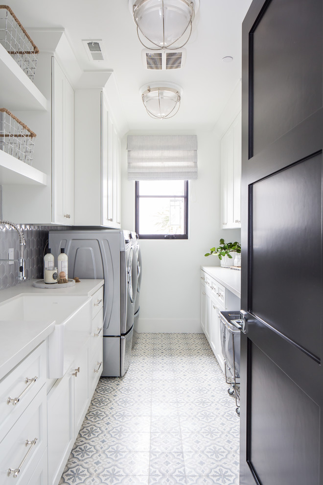 Mediterranean galley dedicated laundry room in San Diego with white cabinets, quartz benchtops, ceramic floors and a side-by-side washer and dryer.