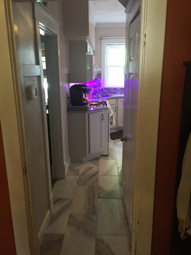 Mid-sized transitional l-shaped ceramic tile and gray floor kitchen photo in St Louis with an undermount sink, recessed-panel cabinets, gray cabinets, granite countertops, multicolored backsplash, glass sheet backsplash, white appliances and multicolored countertops