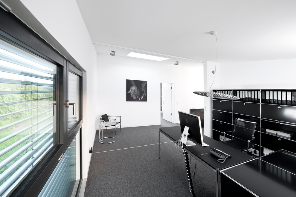Contemporary home office in Nuremberg with white walls, carpet and a freestanding desk.