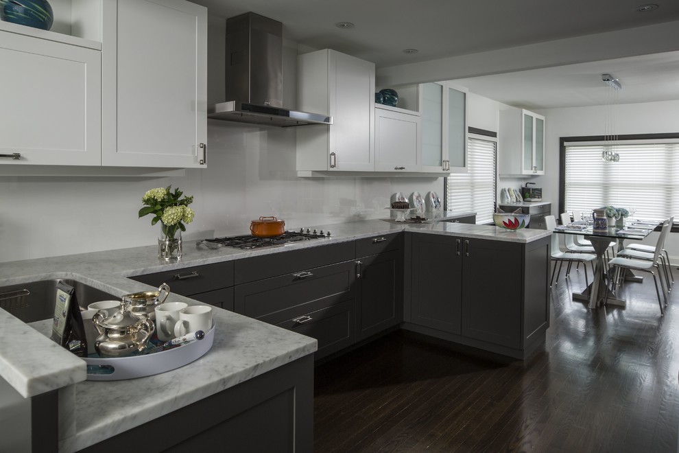 Mid-sized contemporary u-shaped eat-in kitchen in New York with a double-bowl sink, flat-panel cabinets, white cabinets, marble benchtops, white splashback, porcelain splashback, stainless steel appliances, dark hardwood floors and a peninsula.