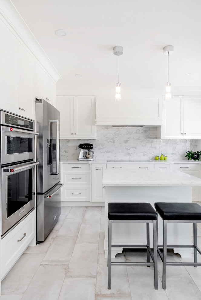 Photo of a mid-sized transitional u-shaped eat-in kitchen in Edmonton with a double-bowl sink, shaker cabinets, white cabinets, quartz benchtops, multi-coloured splashback, subway tile splashback, stainless steel appliances, porcelain floors, with island, beige floor and white benchtop.
