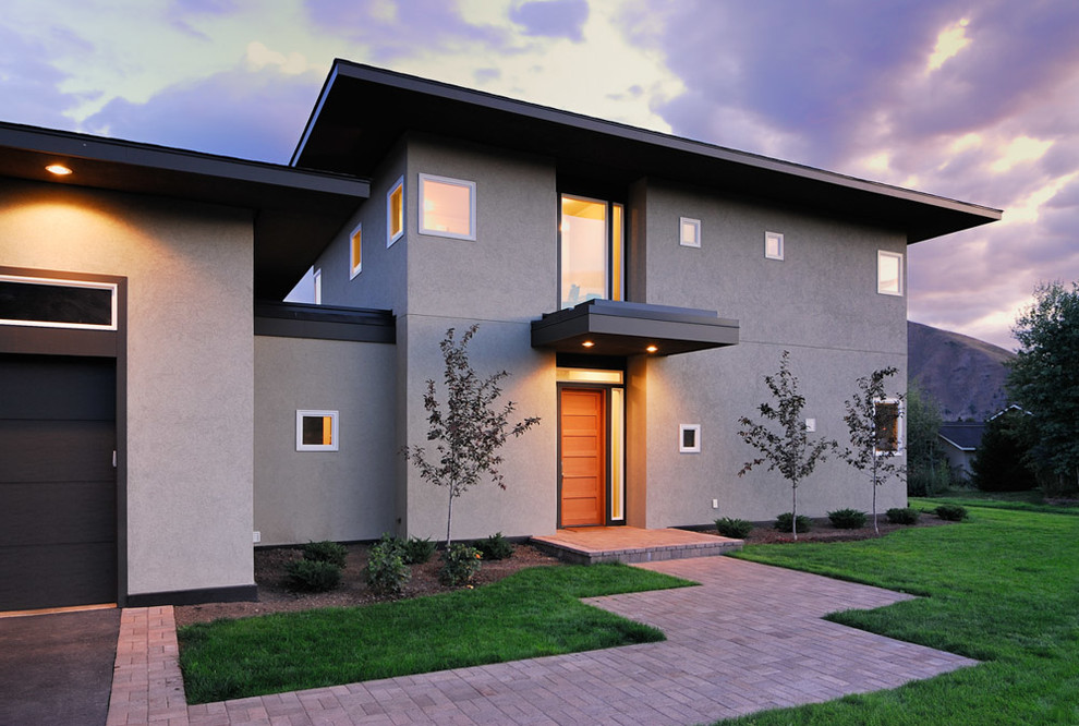 This is an example of a large contemporary two-storey concrete grey house exterior in Other with a shed roof.