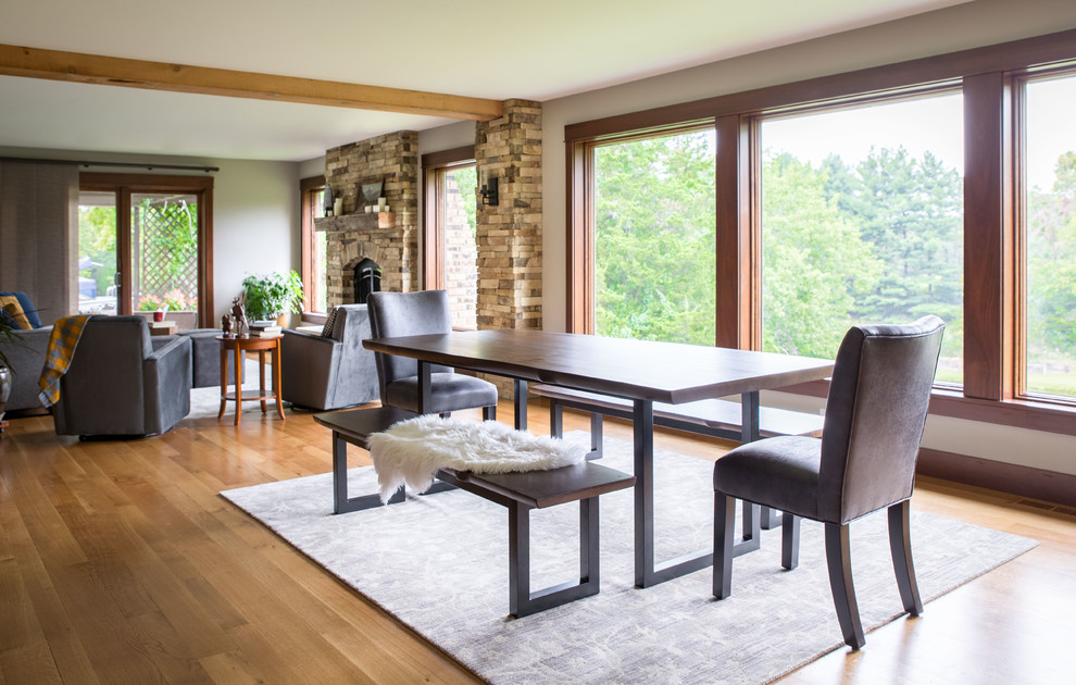 Inspiration for a large rustic light wood floor and beige floor great room remodel in Cedar Rapids with beige walls, a standard fireplace and a stone fireplace
