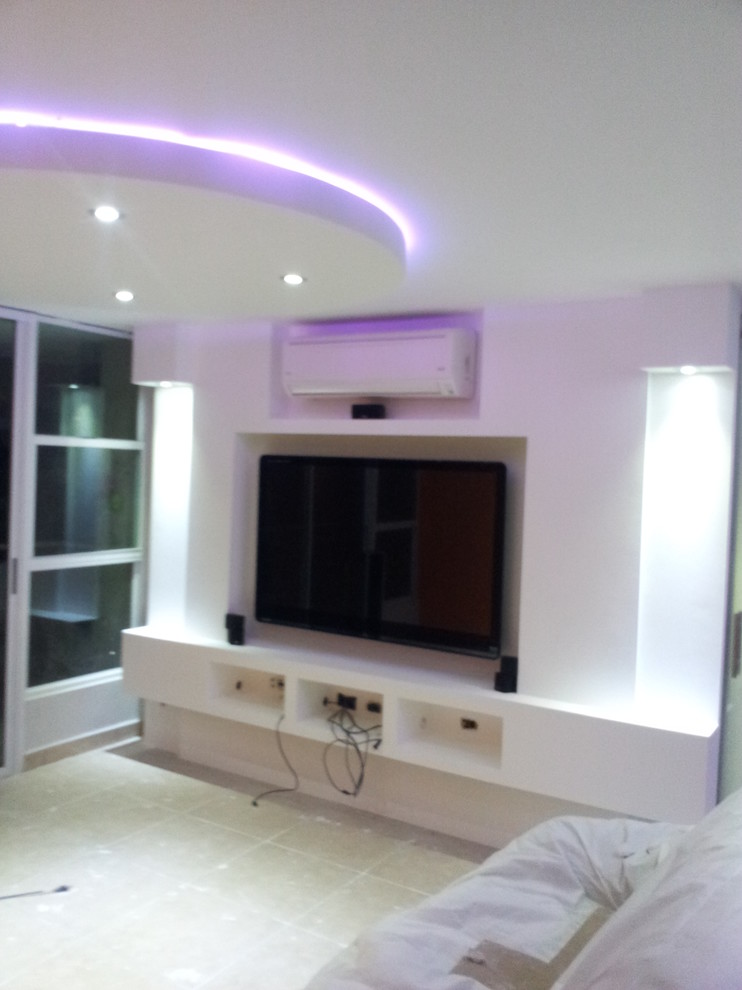 Photo of a large contemporary open concept home theatre in Other with multi-coloured walls, ceramic floors, a built-in media wall and beige floor.