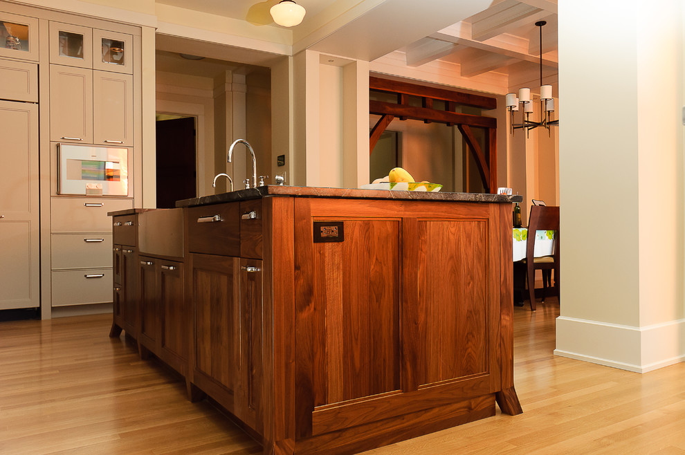 Inspiration for a large transitional galley light wood floor eat-in kitchen remodel in Calgary with a farmhouse sink, granite countertops, paneled appliances, an island, beige cabinets, black backsplash and subway tile backsplash